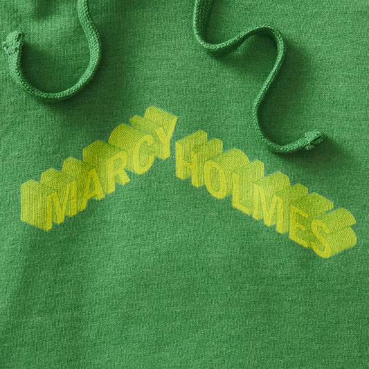 Details of kelly green heather pullover hoodie with Marcy-Holmes text in yellow with isometric effect. neighborhoods, minnesota, twin cities, minneapolis, st paul, minnesota-themed clothing, clothing, apparel, accessories, gifts, goods, hooded sweatshirt, hoodie, sweatshirts, hoodies