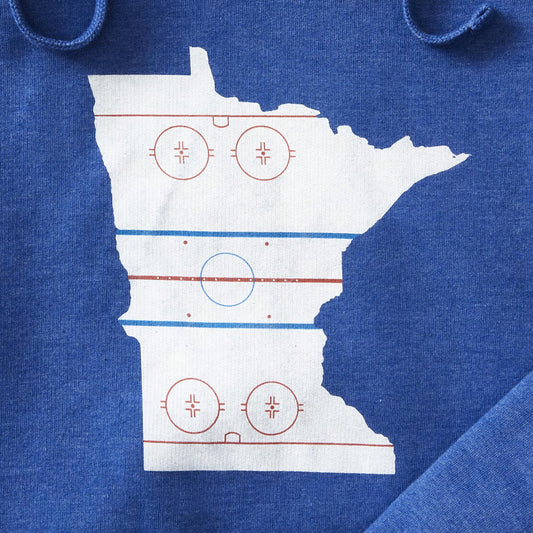 Details of royal pullover hoodie with graphic in the shape of the state outline of Minnesota with the details of a hockey rink on the inside of the state outline. minnesota clothing, minnesota apparel, minnesota accessories, minnesota gifts, minnesota goods, minnesota-themed clothing, minnesota-themed apparel, minnesota-themed gifts, minnesota-themed goods, minnesota hoodies, minnesota hooded sweatshirts, minnesota-themed hoodies, minnesota-themed hooded sweatshirts, minnesota hockey