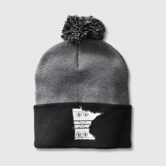 Black & charcoal pom hat with patch in the shape of the state outline of Minnesota with the details of a hockey rink on the inside of the state outline. minnesota clothing, minnesota apparel, minnesota accessories, minnesota gifts, minnesota goods, minnesota-themed clothing, minnesota-themed apparel, minnesota-themed gifts, minnesota-themed goods, minnesota pom hats, minnesota pom pom hats
